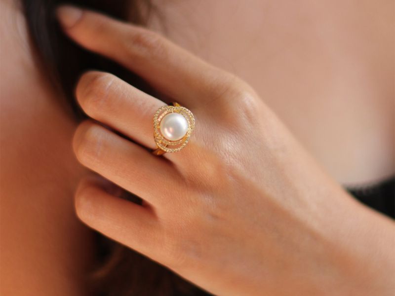 Models hand with a yellow gold marette freshwater pearl ring