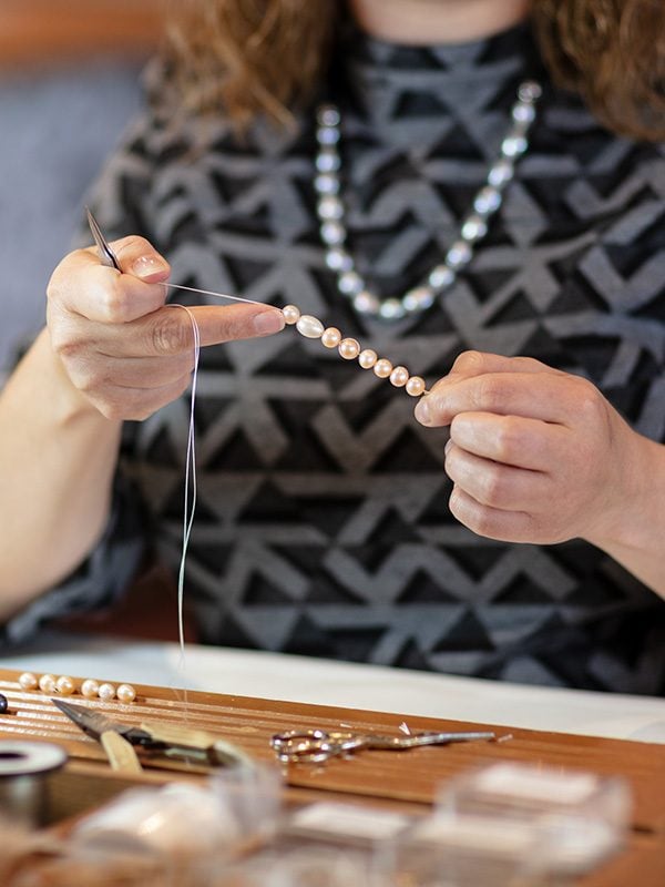 someone restringing pearls in the design studio at isle of wight pearl